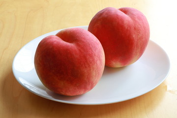 Ripe peaches on white plate