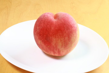 Ripe peach on white plate