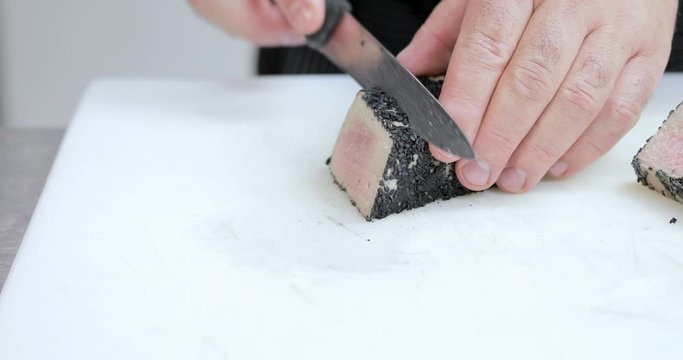 Chef sta tagliando tonno con sesamo nero su un tagliere di un ristorante