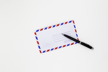 Airmail envelope and black pen on white background.