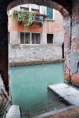 In Venice. Exit to water on one channel and a view of the balcony with flowers