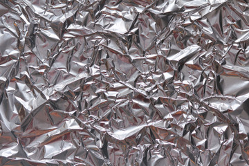 Crumpled foil texture background. Metal  paper shit. Silver aluminum surface.  Gift wrapping shiny paper. Glitter effect.