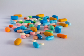 Set of pills and colored capsules in neutral blue background. Drugs in the form of pills. Medicines for human use. Concept of legal drug abuse.