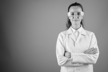 Young beautiful scientist woman doctor against gray background