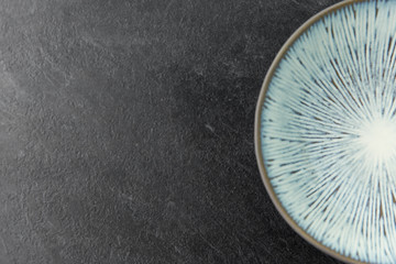 table setting, tableware and eating concept - close up of blue ceramic plate on slate background