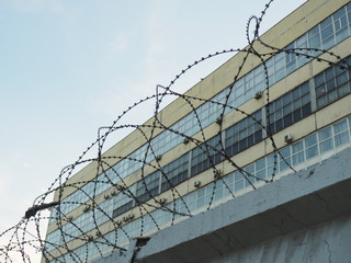 view of the building through a barbed wire fence