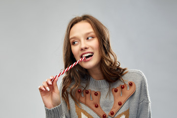 christmas, people and holidays concept - happy young woman wearing ugly sweater with reindeer...