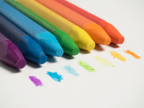 multicolored pastel crayons lie on white paper