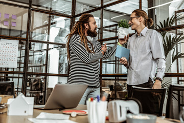 Handsome creative worker demonstrating model of skull