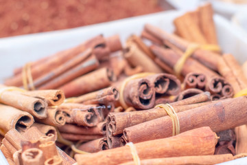 a lot of cinnamon lies on a plate in the market