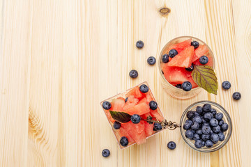 Fresh summer fruit dessert. Sweet watermelon and blueberry, purple basil leaves