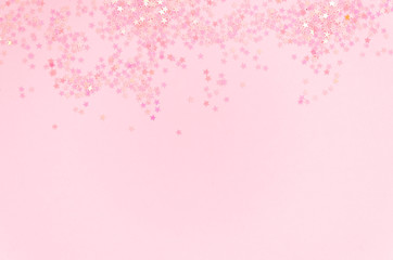 Pink glitter stars confetti frame with copy space on a pink background