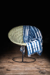 Chaise artisanale isolée sur fond noir avec sol en bois