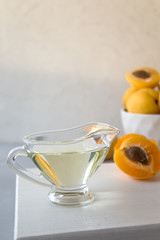 The apricot kernel oil. Gray concrete background. The concept of cosmetology, beauty. Vertical orientation, copy space.