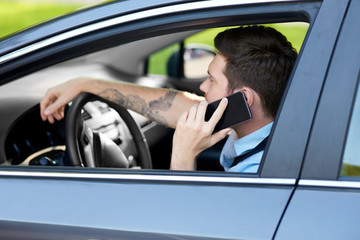 transport, vehicle and people concept - man or driver driving car and calling on smartphone