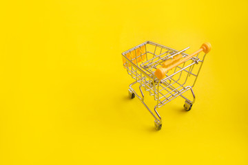 Shopping cart on yellow background