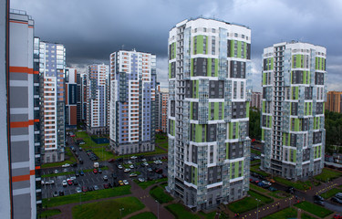 new buildings in a modern residential area in St. Petersburg, yards, Parking, gray clouds in the sky before the rain,