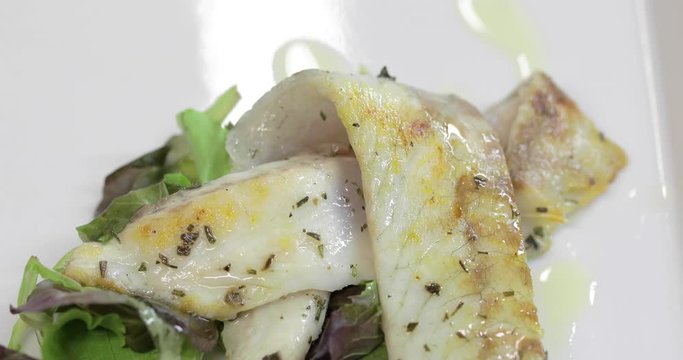 Pesce fresco in un piatto con insalata, pronta per essere servito come secondo in un ristorante