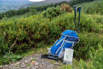 Backpack, binoculars, map and sticks on the mountain, mountain lifestyle in Ireland.