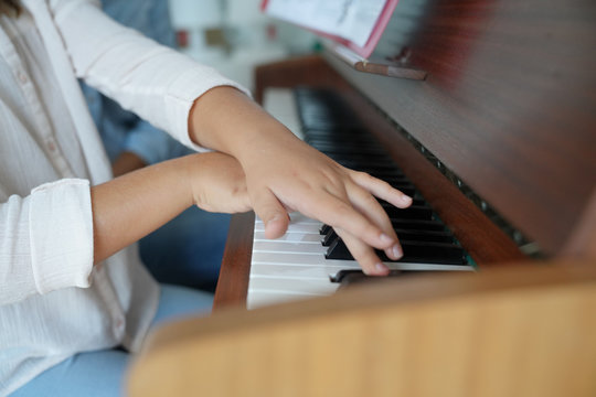 Closeup of child's hands playing the piano