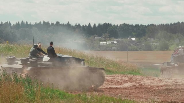 Tanks drive along the sandy road to the battlefield