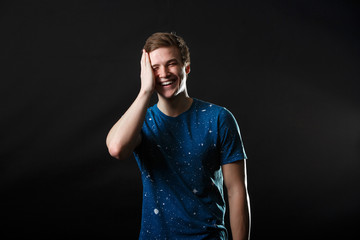 A male in blue t-shirt standing and laughing