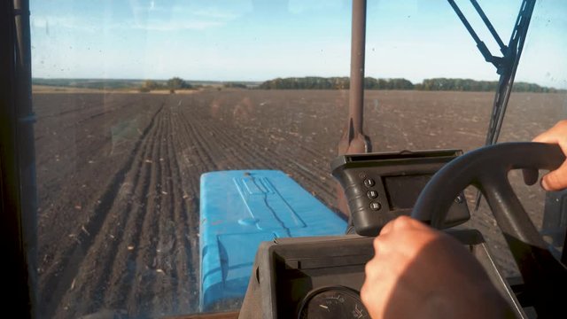 Farmer driving tractor in cultivating field. Agricultural works at tractor.