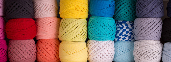 Background from various skeins of yarn. Skeins of colored knit yarn closeup.