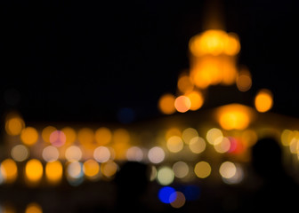 Fototapeta premium Bokeh of building lights. Multi-colored lights of the silhouettes of the building. Building with lights in defocus.
