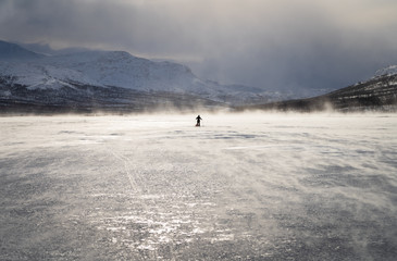 Cross country skier with sled on a frozen river in Lapland. National Park Sarek, Sweden.