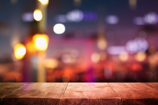 background of wooden table in front of abstract blurred restaurant lights