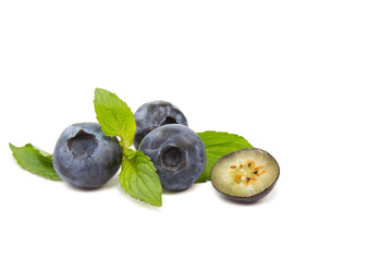 Blueberries with mint leaves, one halved, isolated on white background, copy space