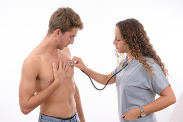 Young caucasian nurse with grey coat and stethoscope auscultate a boy on white background isolated