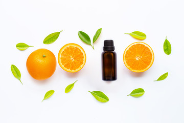 Essential oil with fresh orange fruit and green leaves on white background.