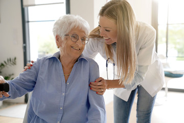 Portrait of elderly woman with nurse a thome