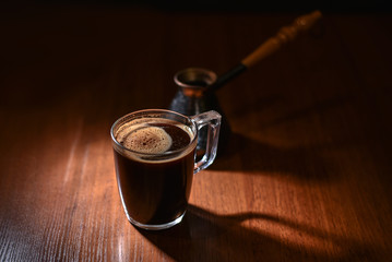 Morning cup of coffee lit by the first rays of the sun. Vintage toned