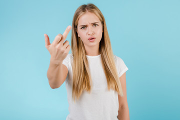Fototapeta premium angry young woman showing middle finger isolated over blue