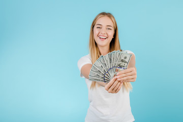 pretty young blonde girl with dollard bills isolated over blue