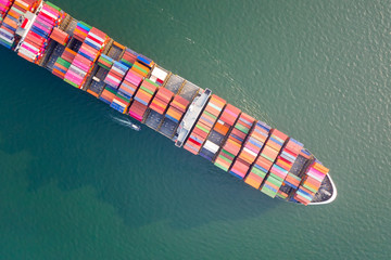 Aerial view of the large volume of TEU container on ship sailing to the sea carriage the shipment from loading port to destination