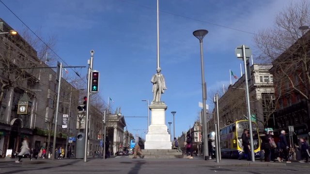 William Smith O'Brien Monument, timelapse. People, cars and buses move on either side of the monument. Dublin. Ireland