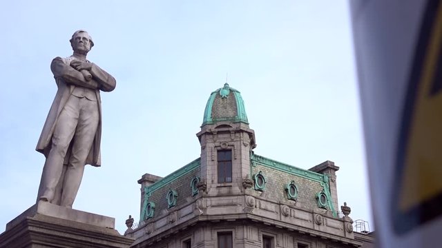 The O'Connell Monument with a vintage rooftop of a building on a side. Dublin, Ireland