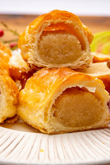 Fresh baked Dutch filled spicy cookies from puff pastry with almonds in autumn colors on dark wooden background