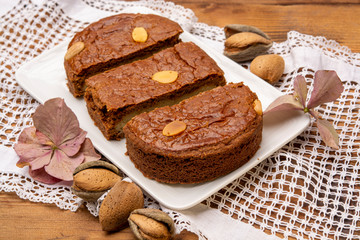 Fresh baked Dutch filled spicy cookies with almonds in autumn colors on dark wooden background