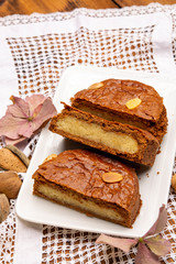 Fresh baked Dutch filled spicy cookies with almonds in autumn colors on dark wooden background