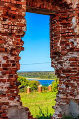 View through window hole of ruined red brick building