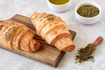 Fresh croissants with zaatar on wooden board 