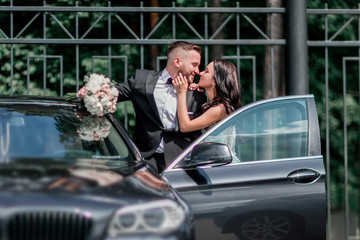 close up. bride and groom standing near the car