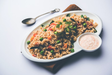 Broken wheat or Daliya Upma, served in a bowl. selective focus
