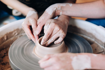 Woman potter teaching the art of pot making. 