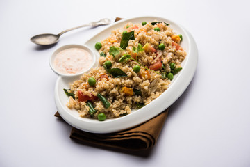 Broken wheat or Daliya Upma, served in a bowl. selective focus